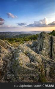 Amazing rocks on the edge of a mountain. Beautiful summer landscape of mountains at sunset