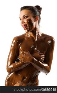 amazing shot of a young beautiful brunette with her naked body covered of sweet cream chocolate