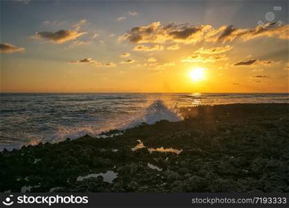 Amazing splash of seawater at sunset on coral rocks. Caribbean Cuba