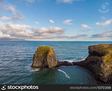 Amazing stone arch Gatklettur basalt rock on Atlantic coast of Arnarstapi in Iceland. The famous natural form arch attracts tourist to visit west of Iceland.