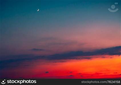 Amazing sunset, beautiful red skyscape with new moon, beauty of moon cycle, sky background