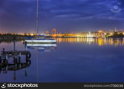 amazing view from a pier to yacht and city lights water reflection