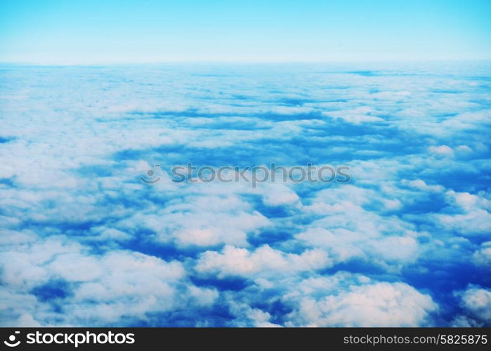 Amazing view from plane on the orange sky, sunset sun and clouds