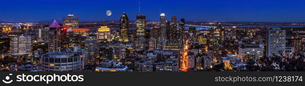 Amazing view of Montreal city at sunset with colorful neon light building. Montreal panorama at dusk as viewed from the Mount Royal overlook. Magic moon over Canadian city.