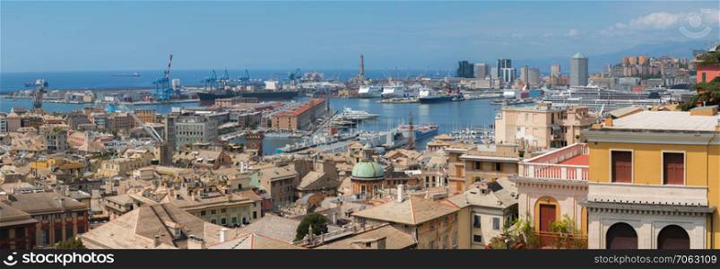 Amazing view of the Genoa city, Italy, with crowded and colorful buildings and the harbor full of ships and activity, under a blue sky.