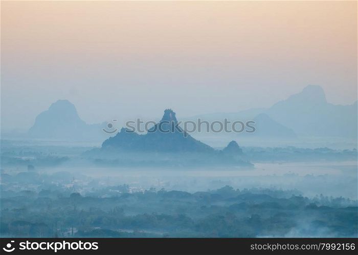 Amazing watercolor view of foggy morning landscape with farm fields and Phar Pu mountain at Thanlwin river. Hpa An, Myanmar (Burma) travel landscapes and destinations