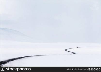 Amazing Winter Landscape. Empty Road among Fields covered with Snow. Natural Grey White Background. Stormy Weather of Iceland.
