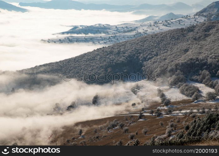 amazing winter landscape with fog and frosty trees in Rimetea Romania