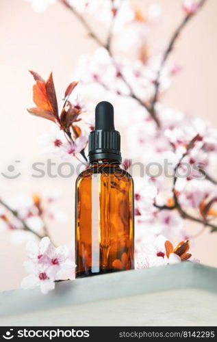 Amber glass dropper bottle with black lid on white marble shelf, natural spring  background. SPA natural organic beauty product packaging design, branding. Beauty salon mockup, low angle view, below the eye line, looking up, hero view