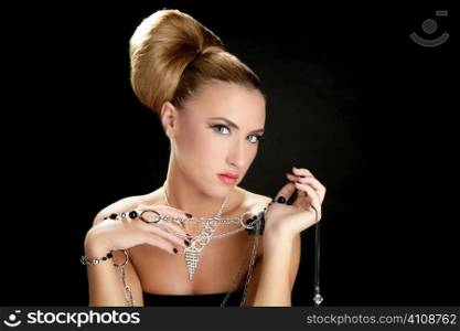Ambition and greed in fashion woman with jewelry in hands on black background