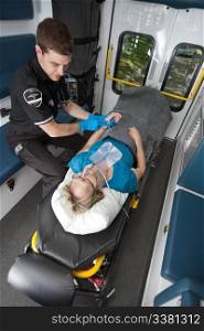 Ambulance professional with senior woman on stretcher