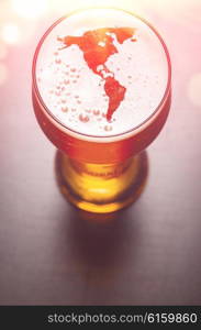 American beer concept, America silhouette on foam in beer glass on black table, view from above