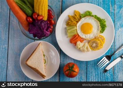 American breakfast on a white background with fried egg, salad, pumpkin, cucumber, carrot, corn, cauliflower, tomato and sandwich 