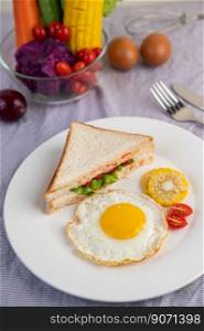 American breakfast on a white background with fried egg, salad, pumpkin, cucumber, carrot, corn, cauliflower, tomato and sandwich 