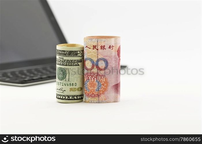 American dollar and Chinese yuan currencies in front of tablet screen and keyboard reflect global trends of investment in technology