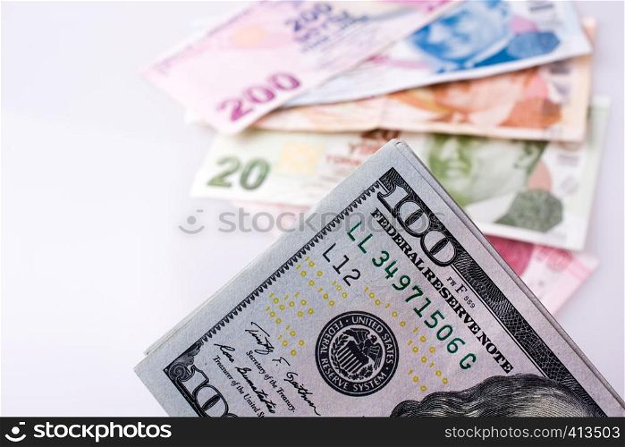 American dollar banknotes and Turksh Lira banknotes side by side on white background