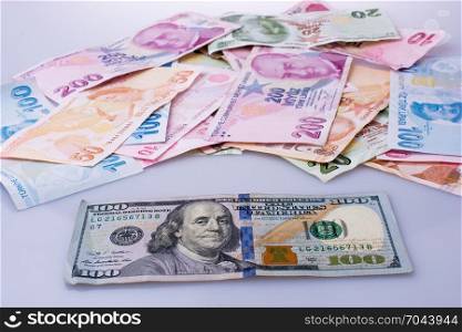 American dollar banknotes and Turksh Lira banknotes side by side on white background