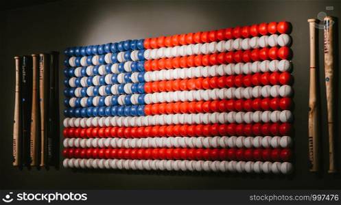 American flag decor assembled from baseball balls and baseball bats on the wall in the cafe,symbol of America, selective focus. Russia, Moscow, 14 March 2019.. American flag decor assembled from baseball balls and baseball bats on the wall in the cafe,symbol of America, selective focus. Russia, Moscow, 14 March 2019