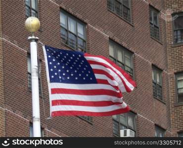 american flag in the breeze in front of a condominium