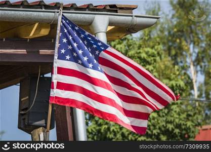 American flag on a porch outside a small cabin in the wild west in the summer