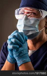 American Flag Reflecting on Distressed Praying Female Medical Worker Wearing Protective Face Mask and Goggles.