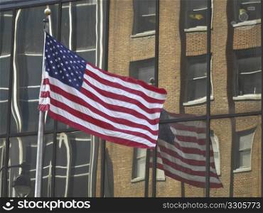 american flag with its reflection in a modern building