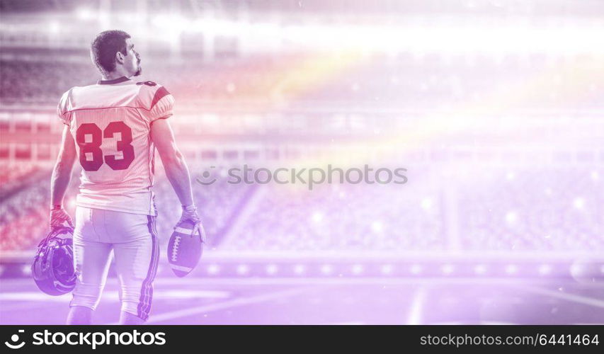 American Football Player isolated on big modern stadium field with lights and flares