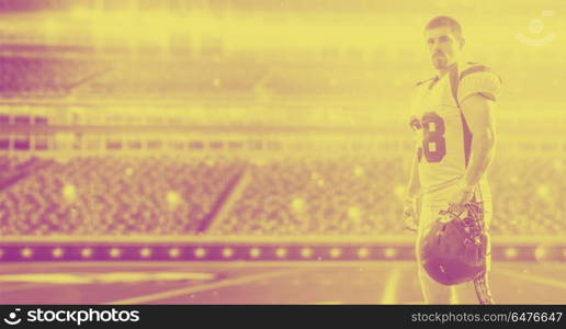 American Football Player isolated on big modern stadium field with lights and flares. American Football Player isolated on big modern stadium field