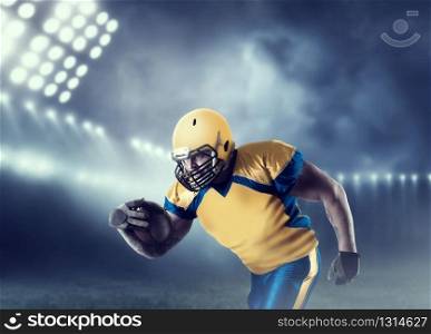 American football player with ball in hands, on sport arena. National league. American football player with ball on sport arena