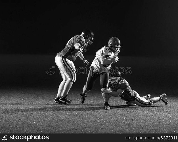 American football players in action at night game time on the field