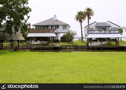 American houses in south Texas green grass river and boats