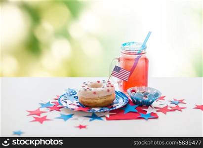 american independence day, celebration, patriotism and holidays concept - close up of glazed sweet donut with flag and candies in disposable tableware at 4th july party over green natural background