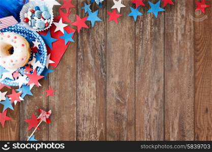 american independence day, celebration, patriotism and holidays concept - close up of glazed donut with candies in disposable tableware and stars at 4th july party from top over wooden background