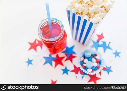 american independence day, celebration, patriotism and holidays concept - close up of juice glass or mason jar, popcorn and candies with stars confetti decoration at 4th july party
