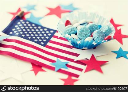american independence day, celebration, patriotism and holidays concept - close up of glazed sweet candies with flag and paper stars decoration at 4th july theme party