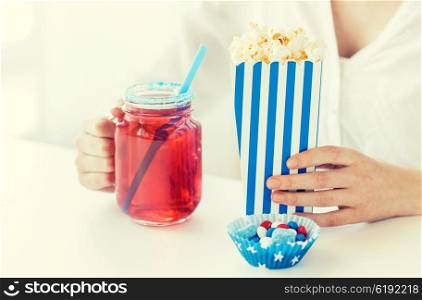 american independence day, celebration, patriotism and holidays concept - close up of woman eating popcorn with drink in glass mason jar and candies at 4th july party