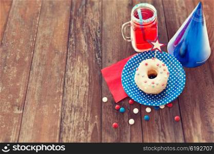american independence day, celebration, patriotism and holidays concept - close up of glazed donut decorated with star, juice and candies at 4th july party from top over wooden table background