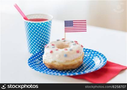 american independence day, celebration, patriotism and holidays concept - close up of glazed sweet donut decorated with flag and juice in disposable tableware at 4th july party