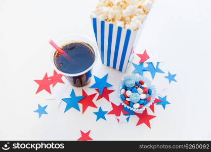 american independence day, celebration, patriotism and holidays concept - close up of coca cola cup, popcorn and candies with stars confetti decoration at 4th july party