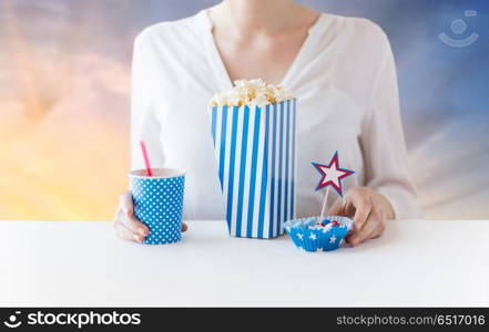 american independence day, celebration, patriotism and holidays concept - close up of woman eating popcorn with drink in glass mason jar and candies at party 4th of july over evening sky background. woman eating popcorn with drink in glass mason jar. woman eating popcorn with drink in glass mason jar