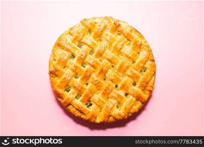 American pie with baked crust on pink background