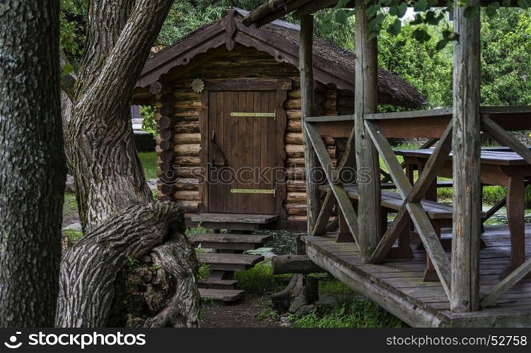 Among the trees is a wooden building and a wooden pergola