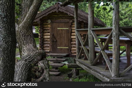 Among the trees is a wooden building and a wooden pergola