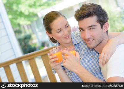 Amorous couple with glasses of juice