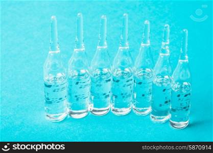Ampoules with medicine closeup on blue background. Ampoules