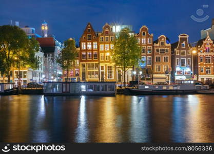 Amsterdam canal Amstel with typical dutch houses and houseboats with multi-colored reflections at night, Holland, Netherlands.