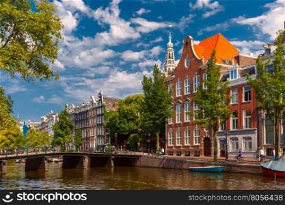 Amsterdam canal, bridge, church and typical houses in the sunny summer day, Holland, Netherlands.