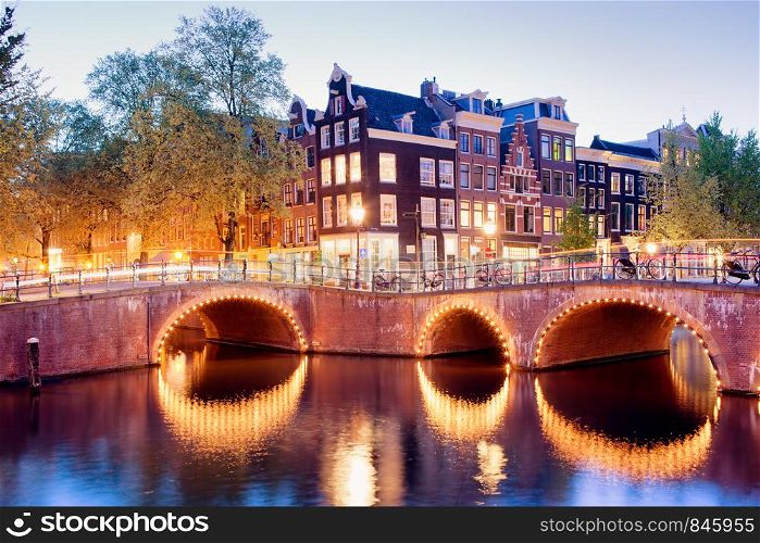 Amsterdam canal bridges illuminated at evening, Netherlands, North Holland province.