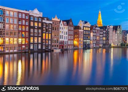 Amsterdam canal with Beautiful typical Dutch dancing houses and Oude Kerk church during twilight blue hour, Holland, Netherlands