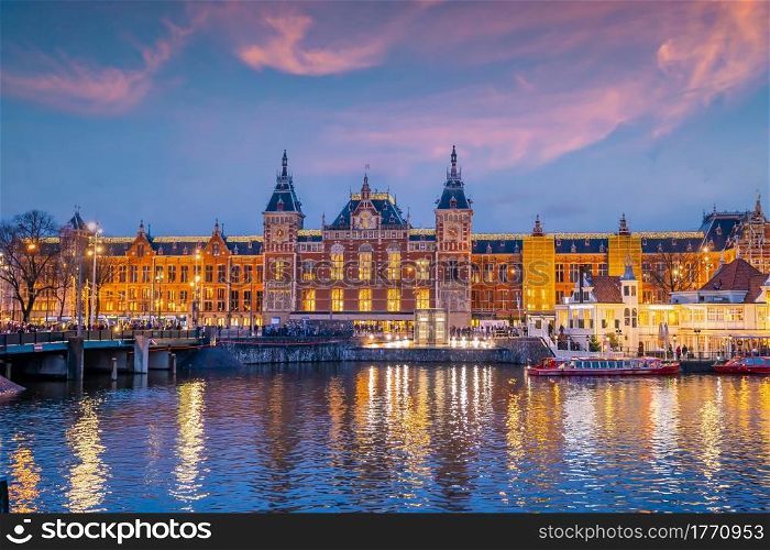 Amsterdam Central Train Station in Netherlands at sunset